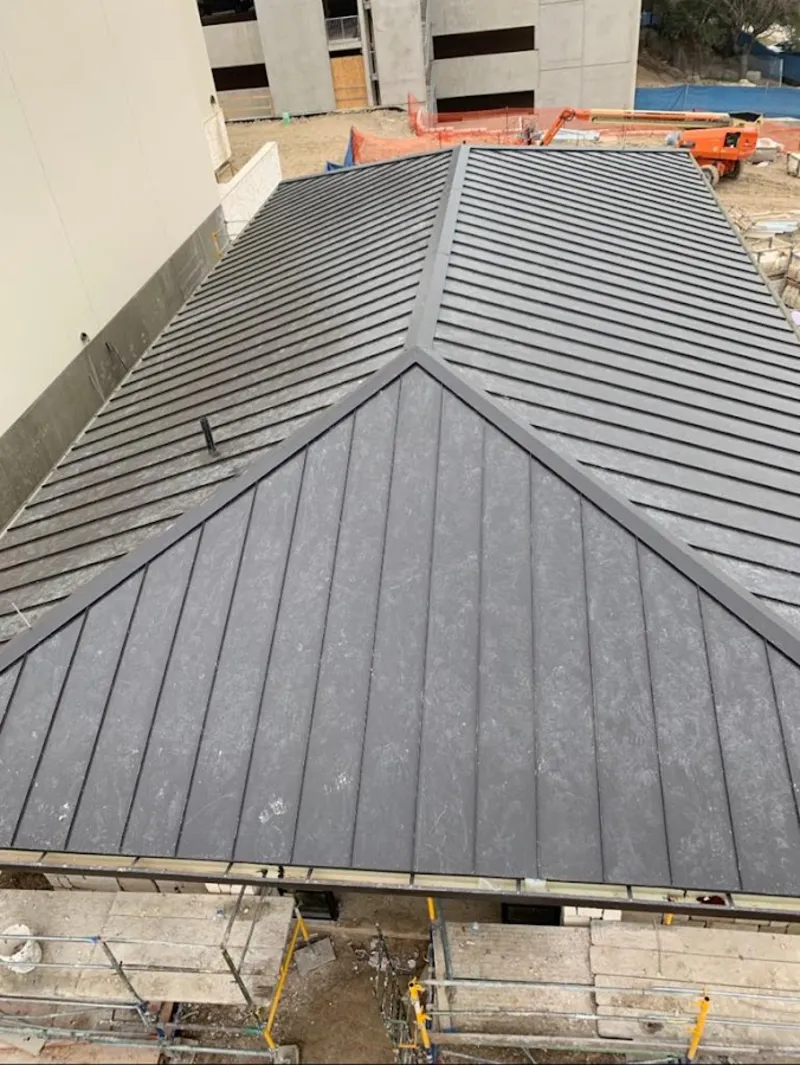 Commercial metal roof construction with crane equipment in Huntington